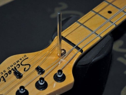 Truss rod adjustment is usually done at the nut end of the neck on electric guitars.