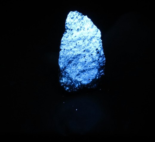 The fluorescent mineral diopside glowing bright blue/white in Shortwave UV light.