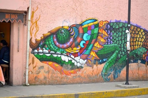 colorfull grafitti of a chameleon on entire pink wall outside the station of tren ligero of Xochimilco
