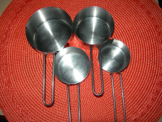 Nested metal measuring cups in 1/4 cup, 1/3 cup, 1/2 cup and 1 cup gradation.