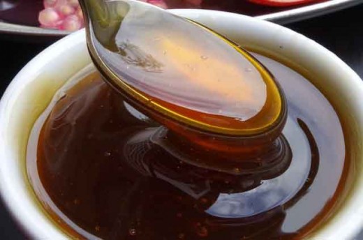 A spoonful of honey showing its golden thickness.