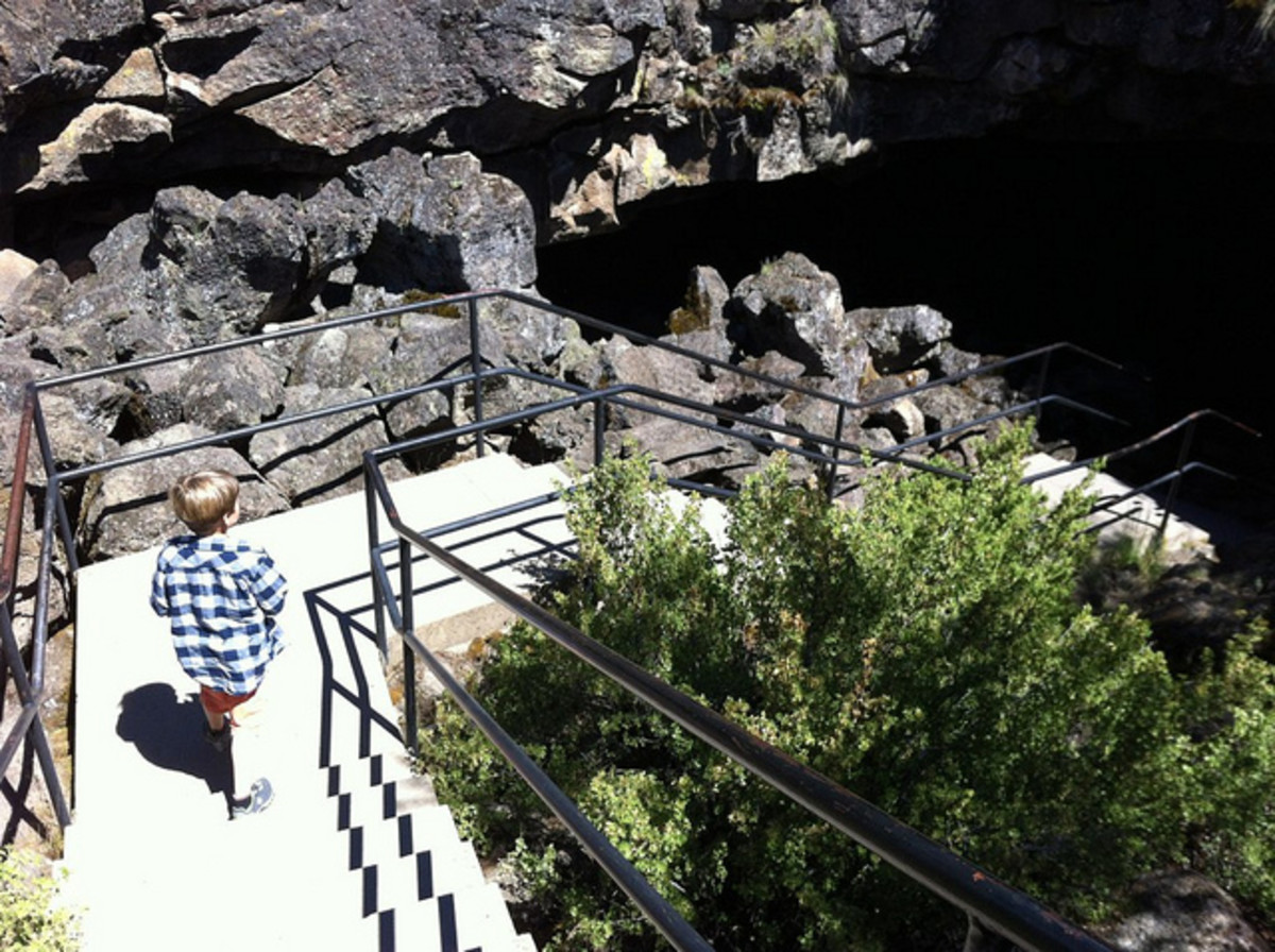 The bright, sunlit stairway to the cave entrance gives no clue to the pitch blackness within .