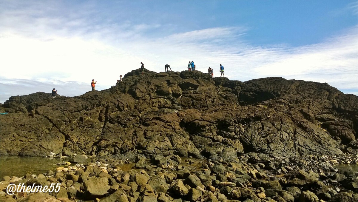 Filipino  tourists climbing on top of the left side of Laswitan rock formations before they were discovered by the administration. 