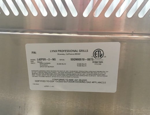 All grills are required to have an information sticker that provides Manufacturer, Country of Origin, Model Number, Serial Number, BTU's, Gas Type, etc. Lynx Grills places theirs underneath the drip tray.