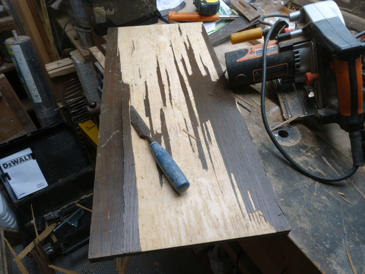 Removing loose veneer with a chisel.