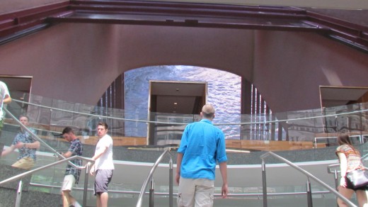 A display of various videos are presented on a wall near the steps with Comcast Center.