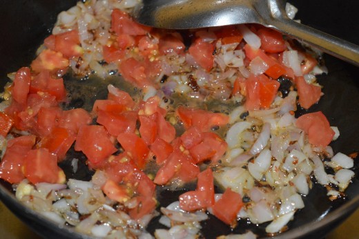 Step four: Add chopped tomato to the pan. Continue cooking on medium-high fire.