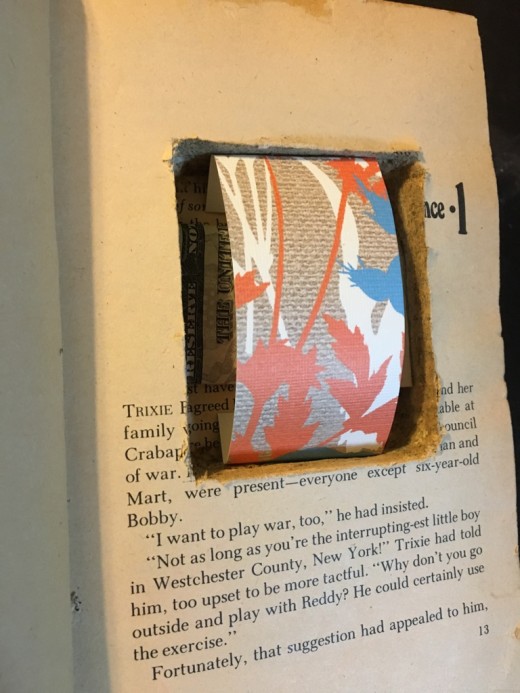A strip of scrapbook paper holds the money in place.
