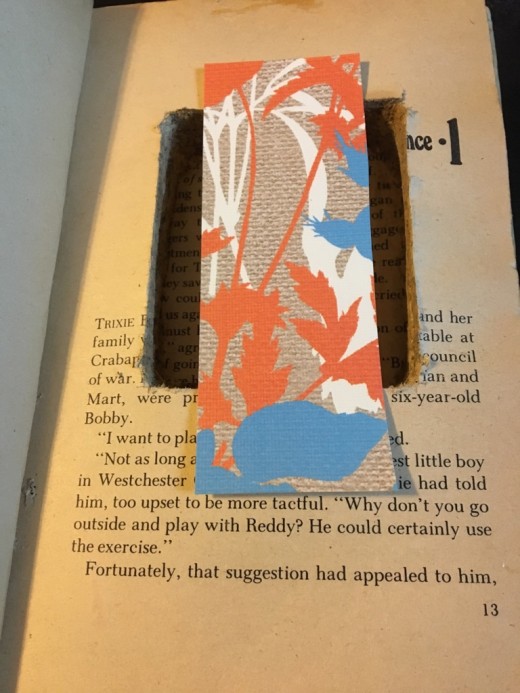Cut a strip of scrapbook paper or card stock that is a little narrower than the width of the hole, but an inch longer.