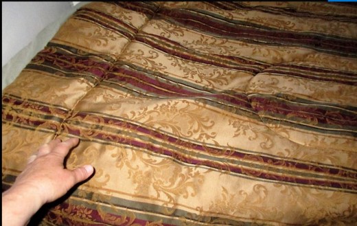 Making the bed - pulling a multiple layer of blankets up to top of bed, lifting and pulling and a small amount of tucking