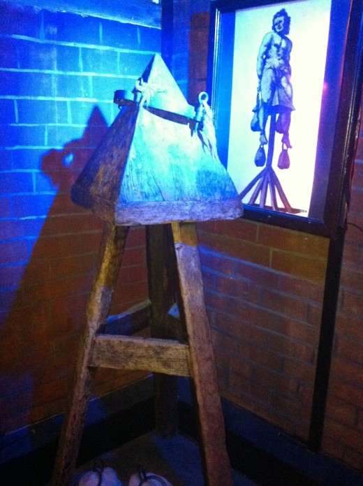 The Judas Cradle would involve the person sitting on the point of the pyramid with weights attached to their arms and legs