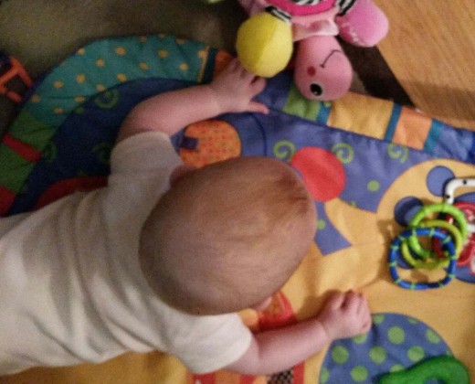Tummy time is becoming more important for strengthening neck, shoulder and back muscles. Placing articles just out of reach, encourages Imogen to move toward them, by scooting, rolling or crawling.