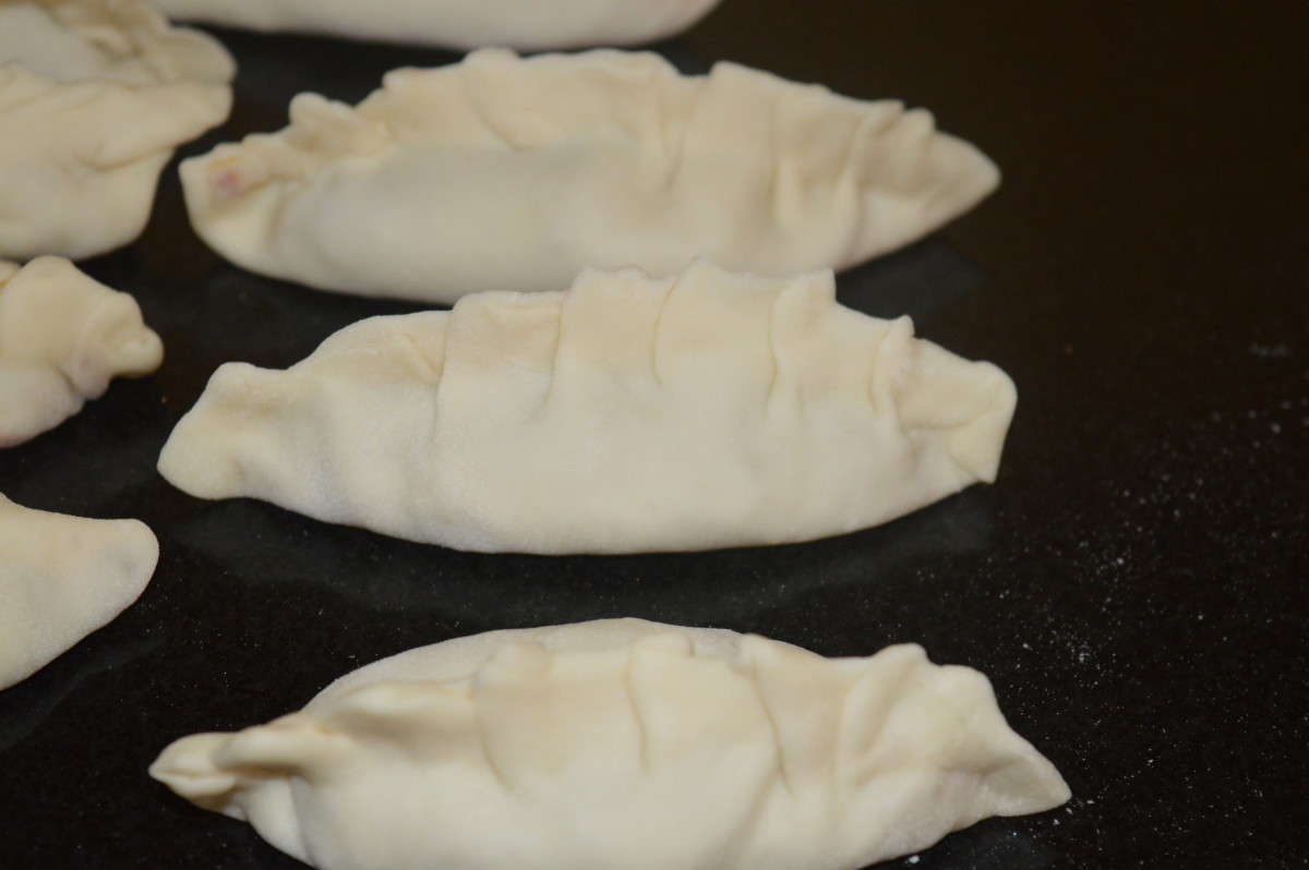 Fold the open ends by making pleats and close the edges. Prepare 10-12 such dumplings in a batch.