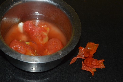 Step three: Remove the skin of the tomatoes. Discard it.