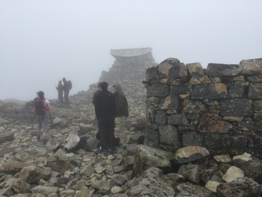 The ruins of the old weather station with the storm shelter behind it.