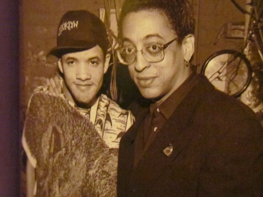 Photo from the publication of "Savion Glover and Gregory Hines, appeared, c. 1990. Top right: Poster for Glover's Apollo show 'Improvography.'"  