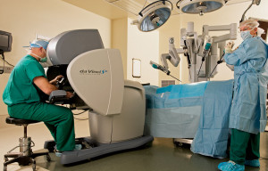 A doctor oversees a robot surgeon at work performing surgery on a patient.