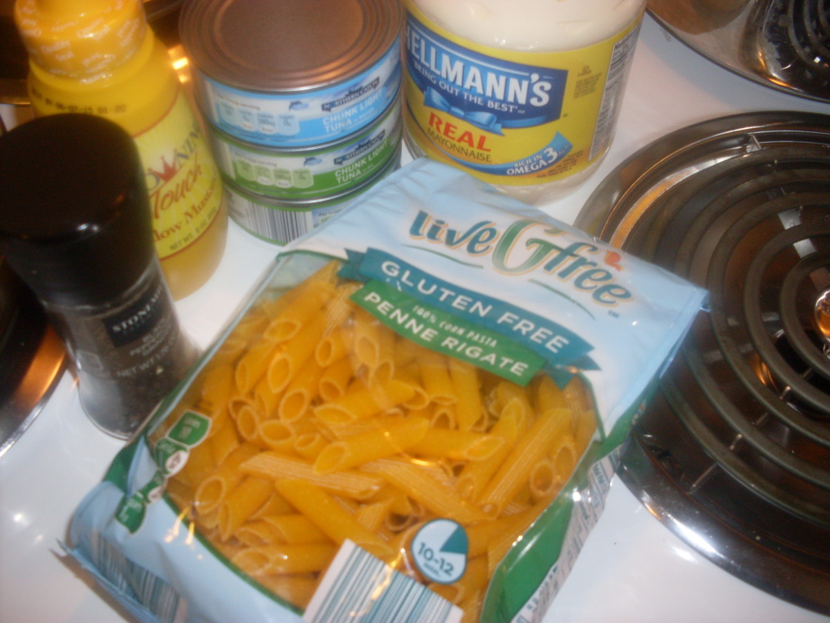 The package of penne pasta, 3 cans of tuna fish, mayo, mustard and black pepper are pictured here.