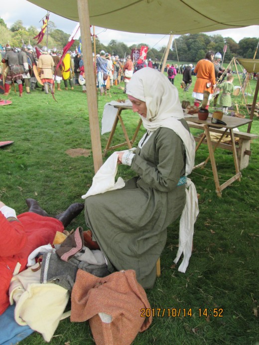A tense time: patiently stitching in the entrance to her husband's tent, a wife awaits his return from the fight on 14th October, 1066. 