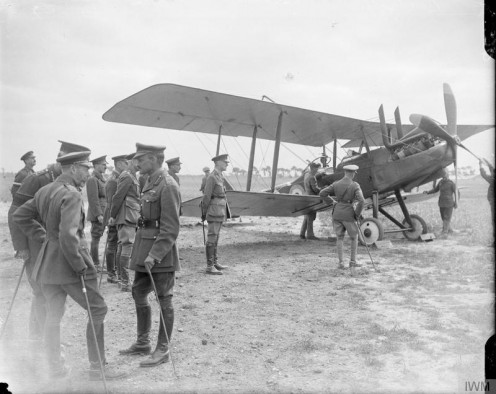 The Official Visits To the Western Front, 1914-1918 King George V with Brigadier General John Becke at the Bray-Dunes aerodrome, 5 July 1917. Edward, the Prince of Wales, is looking at a Royal Aircraft Factory R.E.8 biplane.