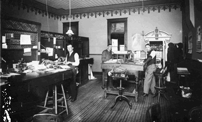 Three men working in a bank in a small town early in the twentieth century ( one is the grandfather of the author)