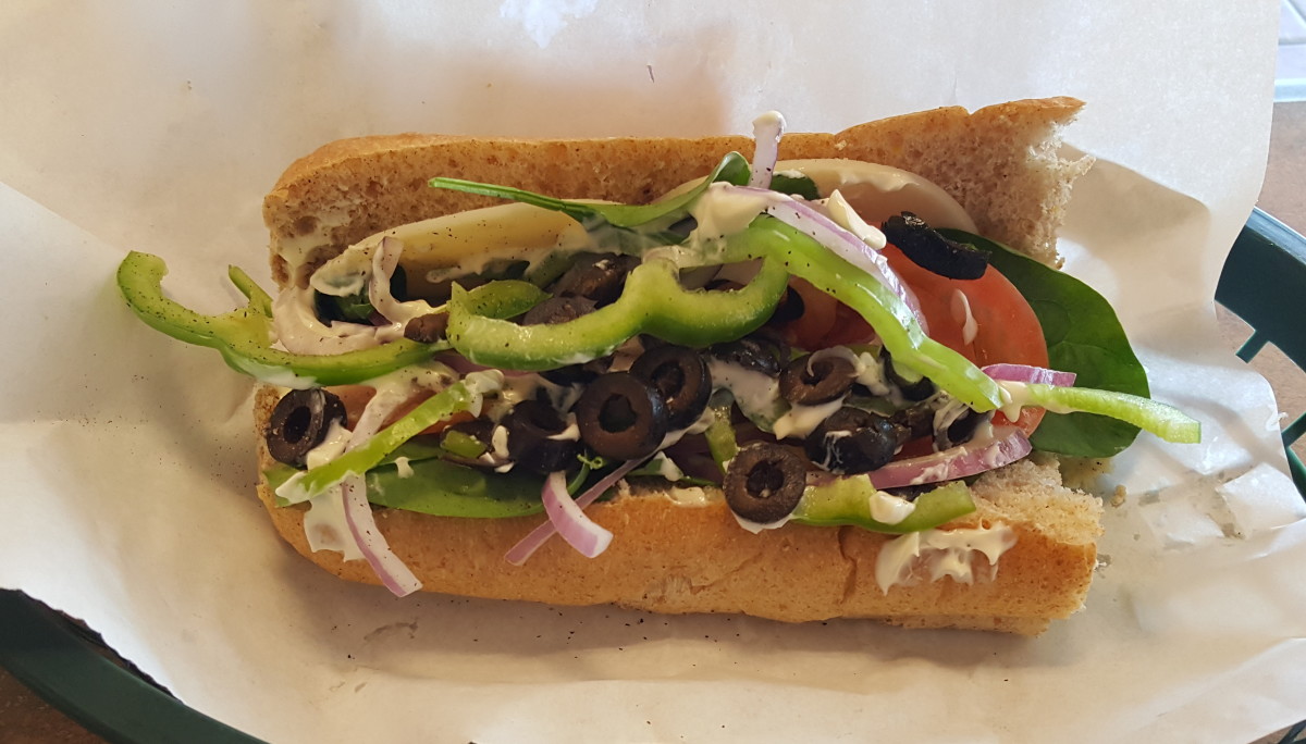 Veggie Delight sub on 9-grain wheat bread with provolone cheese, spinach, tomato, bell pepper, onion, olives, mayo, salt, and pepper.