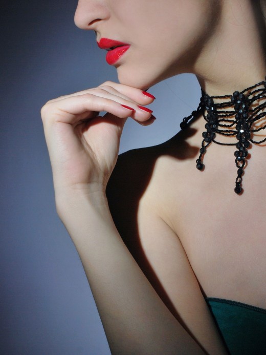 Black acrylic choker graces a neckline. 