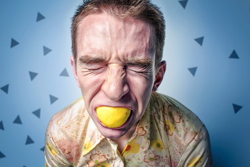 A man biting on a lemon to ease stress