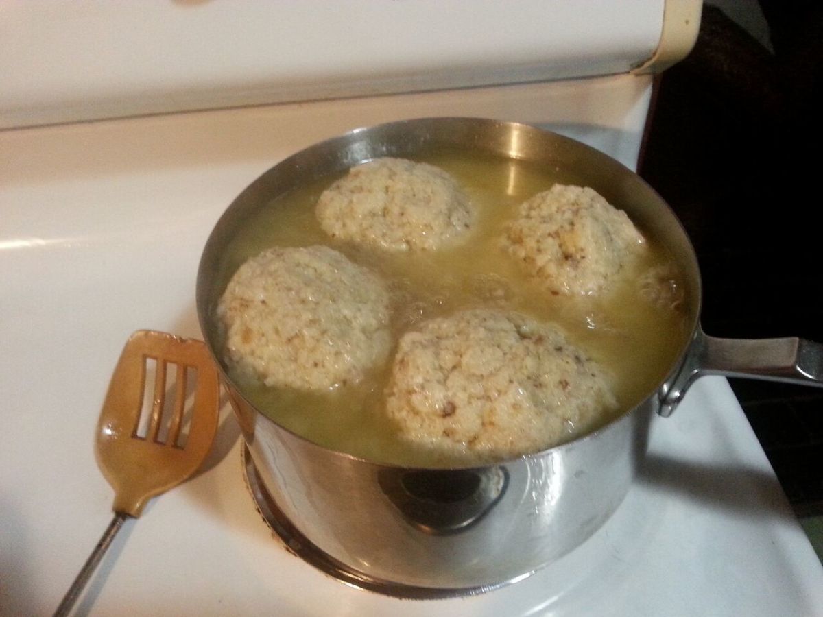 Matzo balls simmering in chicken broth
