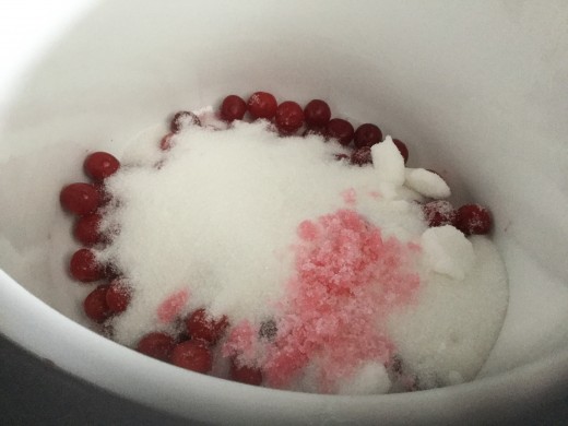 Adding sugar to the fruit in the pan