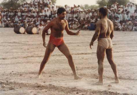 Two competitors in Kabaddi, which is a team sport, face off at a match being played in Burewala, district Vehari of Punjab.