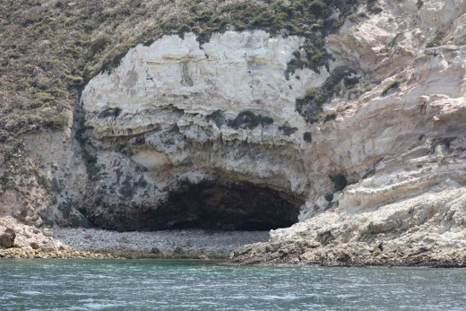 A small beach and a cave on the west side of the harbor.