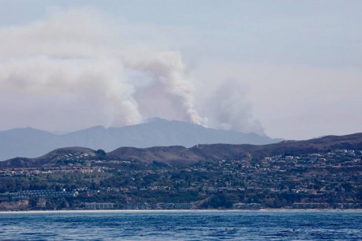 Here the Holy Jim fire is seen from offshore of Dana Point. The smoke went straight up what looked to be over 3,000 feet. Then winds from the east blew the smoke to the west in a big. Cloud parallel to the ground.
