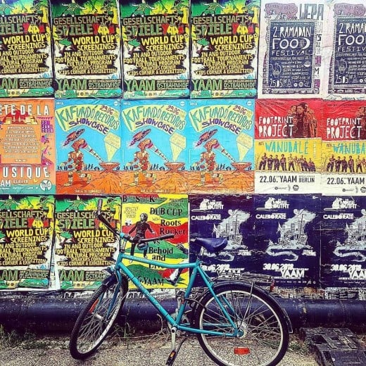 A bike rests in front of a smorgasbord of posters.  