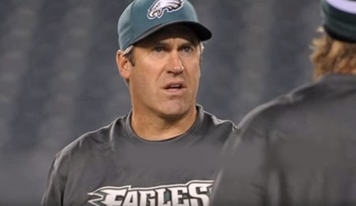 Philadelphia Eagles head coach Doug Pederson listening to someone explain what a running play is