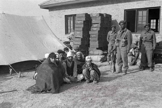 Captured Pakistan tribesmen being guarded  by Indian soldiers