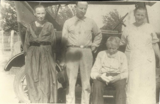 Abraham Bates Tower (seated on the running board) and three of his adult children.