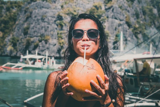 This girl is enjoying a drink inside a coconut.