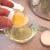 Separate the halves of the broken egg, over a container, allowing only the white to drain from the egg half.