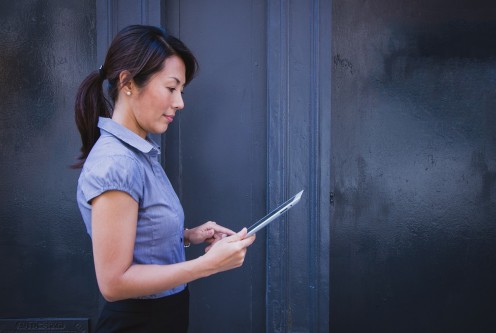 A woman looking at her tablet.