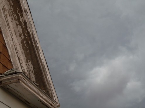 Clouds rush by above the eaves of the house. The air is perfectly still.