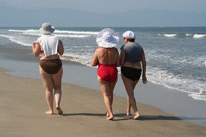 Three older women walking along the beach, not yet in great shape, but enjoying the exercise and the fresh air.  