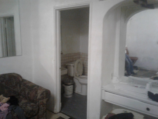 A bathroom and a mirroed alcove