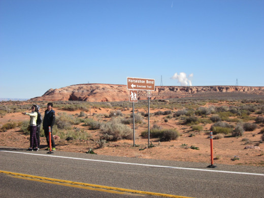 Road sign for Horseshoe Bend showing avid tourists who parked along US 89 (not permitted).