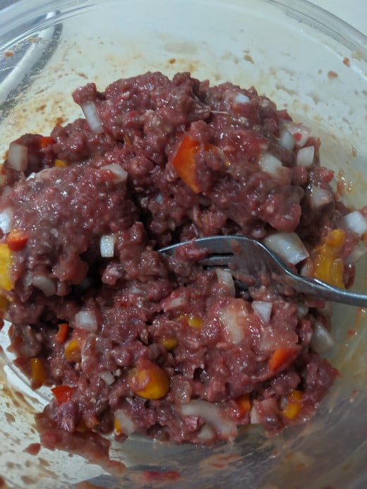 Add peppers, onions, seasoned salt, eggs and milk to meat.