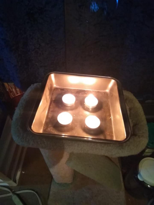 This is the base of a ceramic heater consisting of a baking pan and four tea lights.