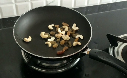 Roasting cashew nuts and raisins in ghee to garnish