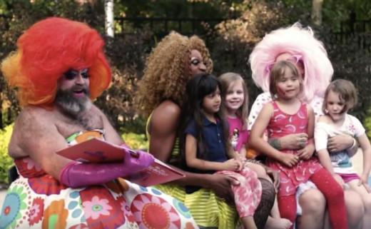 Men in drag holding children at drag queen story hour