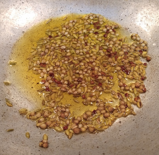 To this hot oil, add methi seeds, coriander seeds and fennel seeds. Let them crackle.