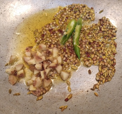 Add chopped ginger and slit green chilies. Fry till ginger starts smelling good.
